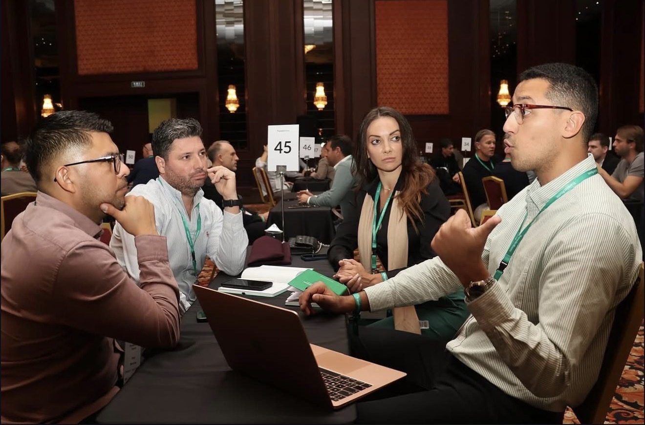 Four people in discussion around a table with a laptop at a TransferRoom event in Istanbul